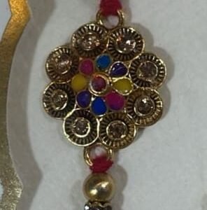 Colorful beads surround a golden, intricate flower  rakhi
