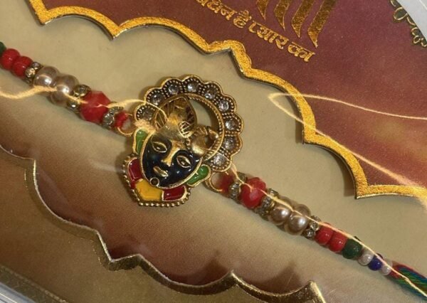 A thread featuring a Krishna-like face on a colorful rakhi