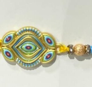 A vibrant Rakhi with a golden, evil-eye-inspired  braided, multicolored thread.